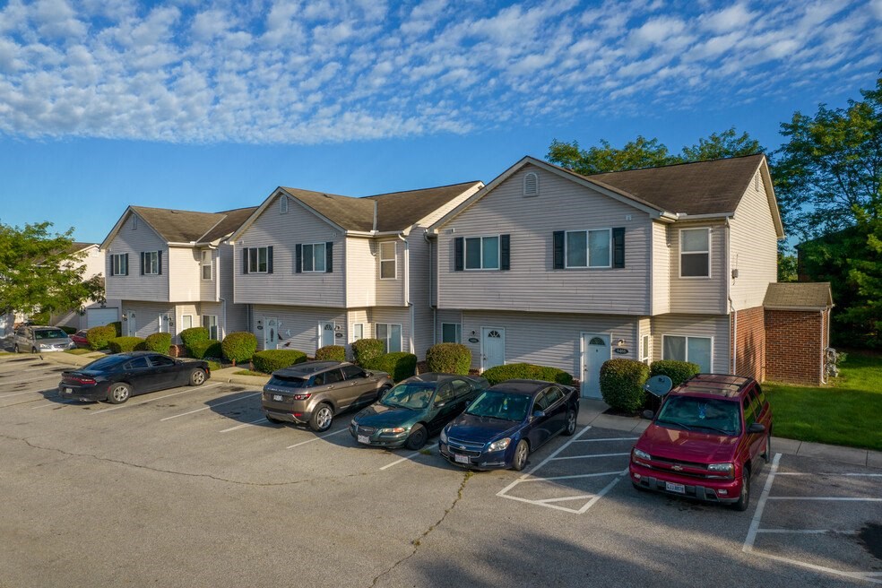 an apartment building with cars parked in a parking lot
