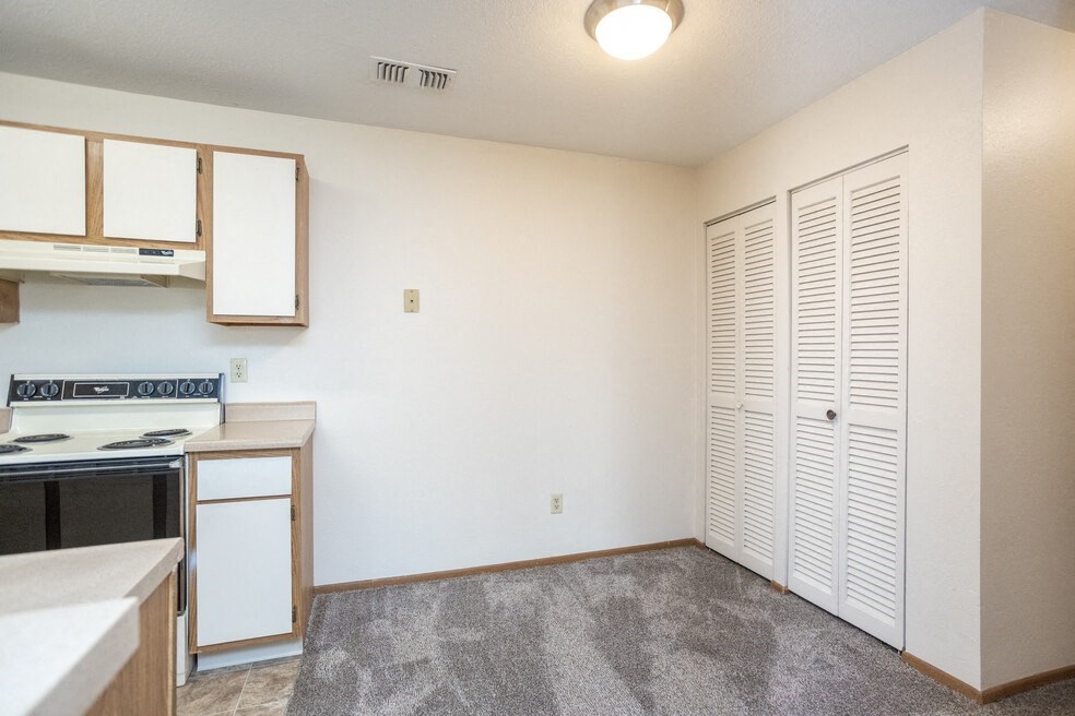 an empty kitchen with white cabinets and a stove top oven