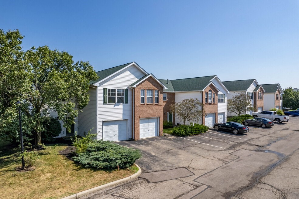 a row of houses with cars parked in a parking lot