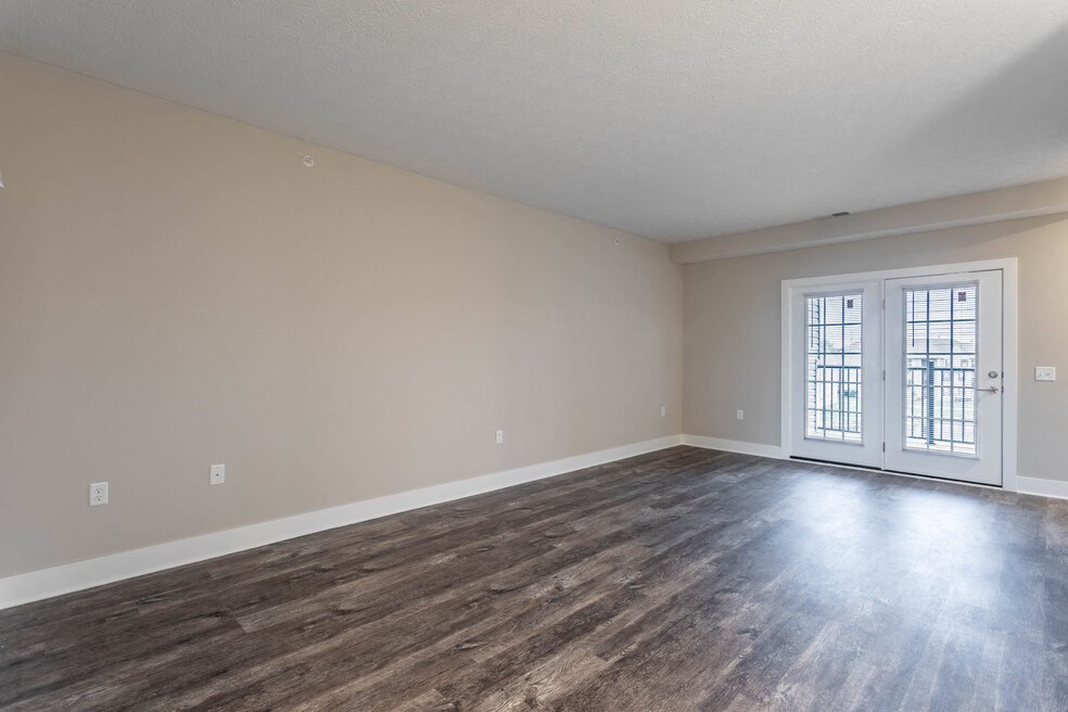 the living room and dining room of an empty home with wood flooring