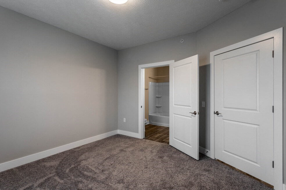 a bedroom with a closet and a door to a bathroom