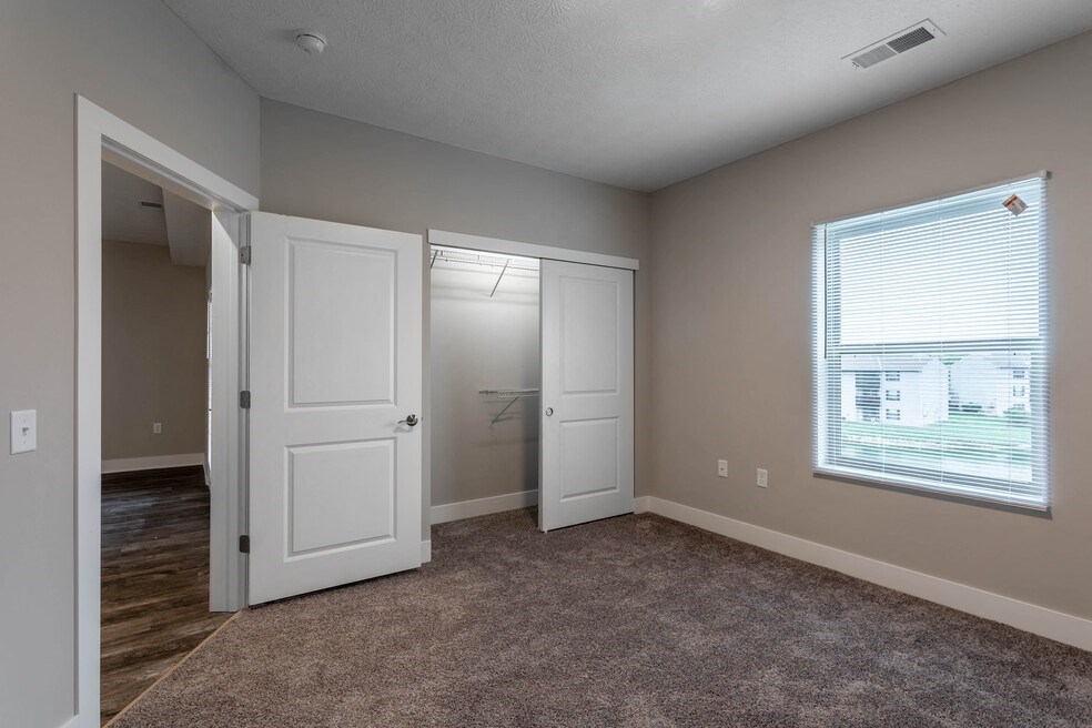 an empty living room with two doors and a window