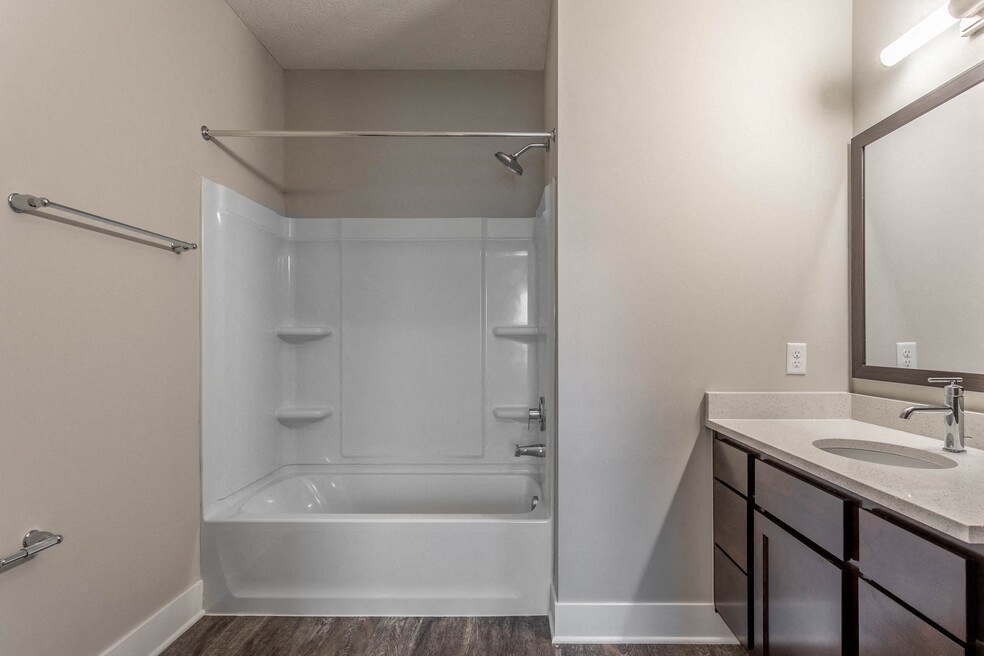 a bathroom with a shower and a sink and a mirror