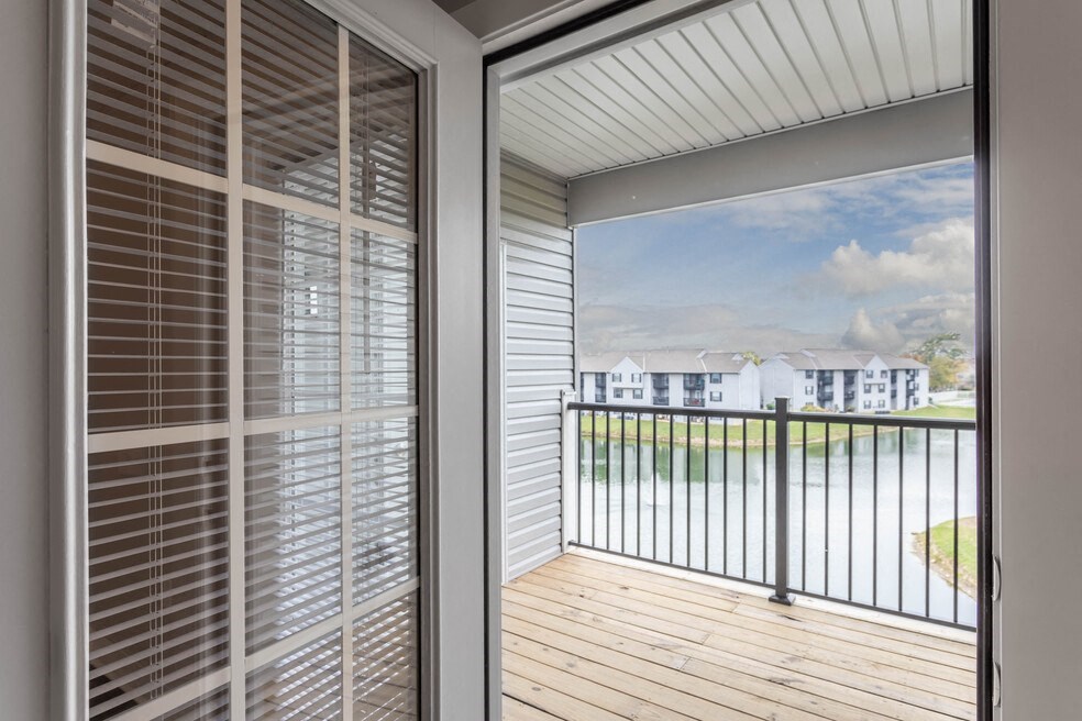 the view from the deck of a home with white blinds and a balcony