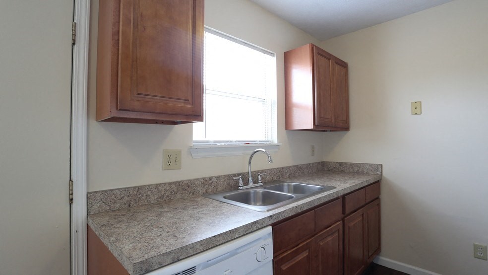 an empty kitchen with a sink and a window