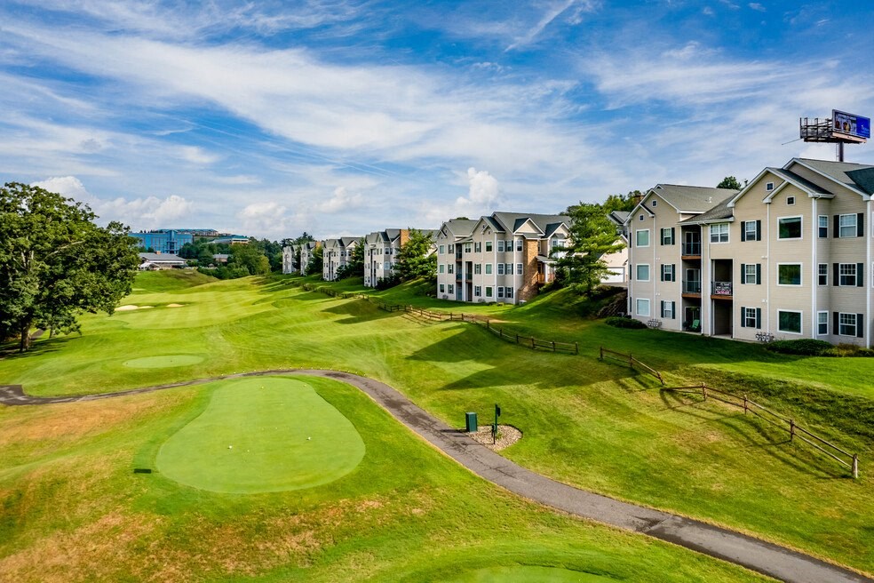 a view of a golf course with apartments in the background