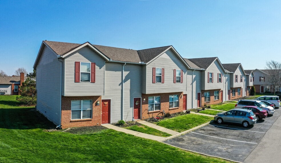 a row of houses with cars parked in a parking lot