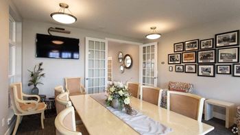 A dining room with a long table and chairs.