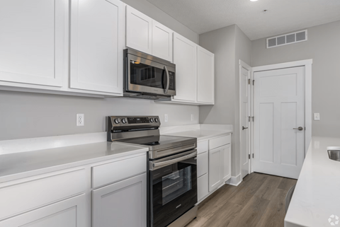 A kitchen with white cabinets and appliances.
