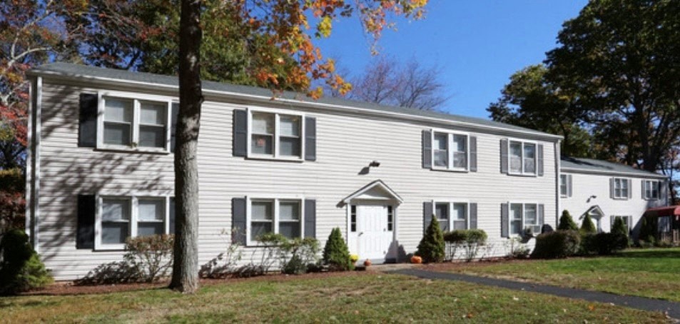 a white house with black shutters and a tree