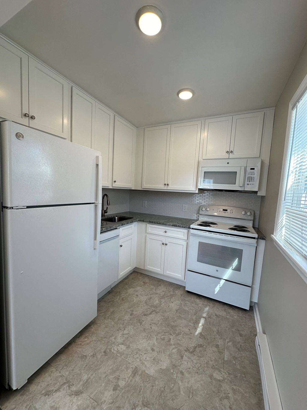 a kitchen with white appliances and white cabinets
