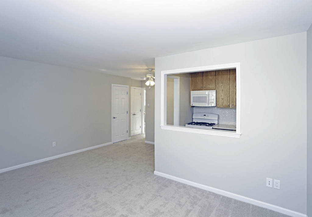 A white room with a window and a microwave.