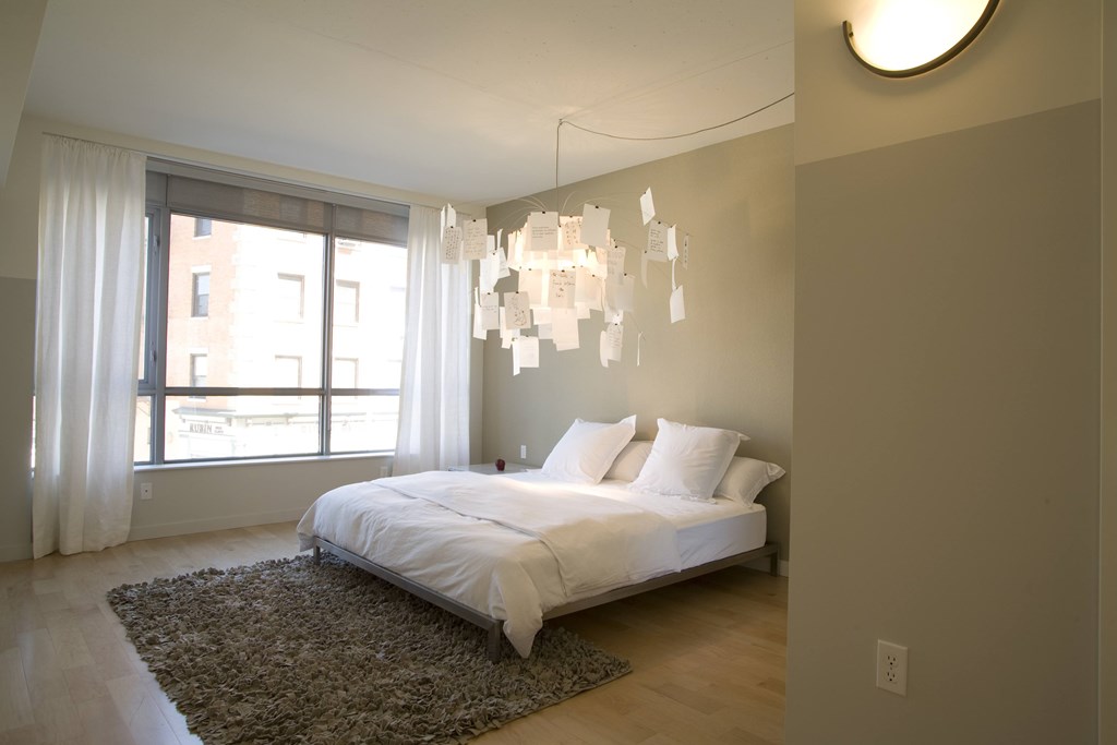 A bedroom with a large bed and a chandelier. A bedroom with a large bed and a chandelier.at 66 Main, Yonkers