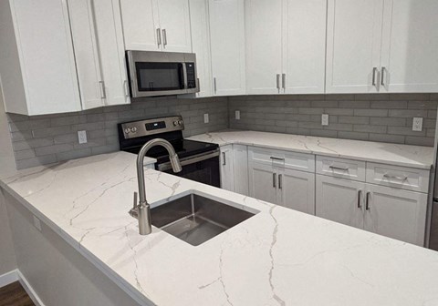 a kitchen with white cabinets and a sink