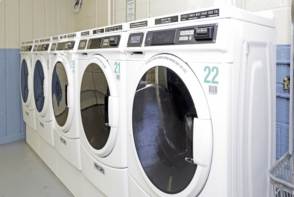 A row of white front load washing machines with the number 22 on the front.