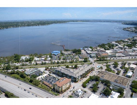 A large body of water is surrounded by buildings and a highway.