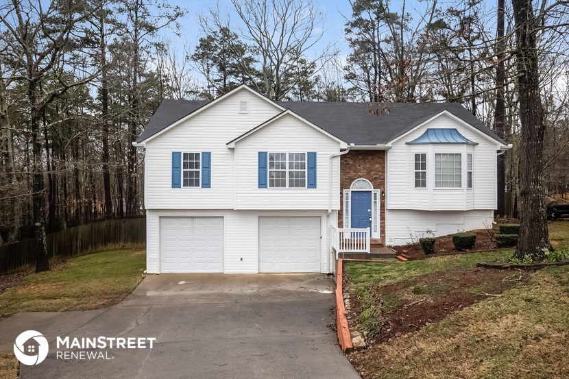 a white house with blue shutters and a driveway