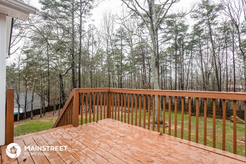 the deck is overlooking the yard and the woods