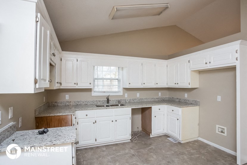 a kitchen with white cabinets and counter tops and a sink
