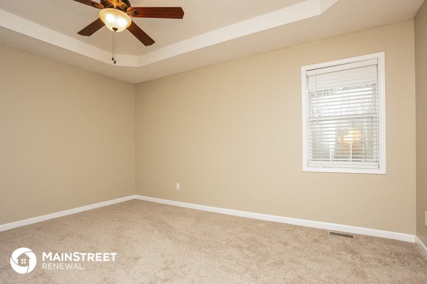 a bedroom with a ceiling fan and a window