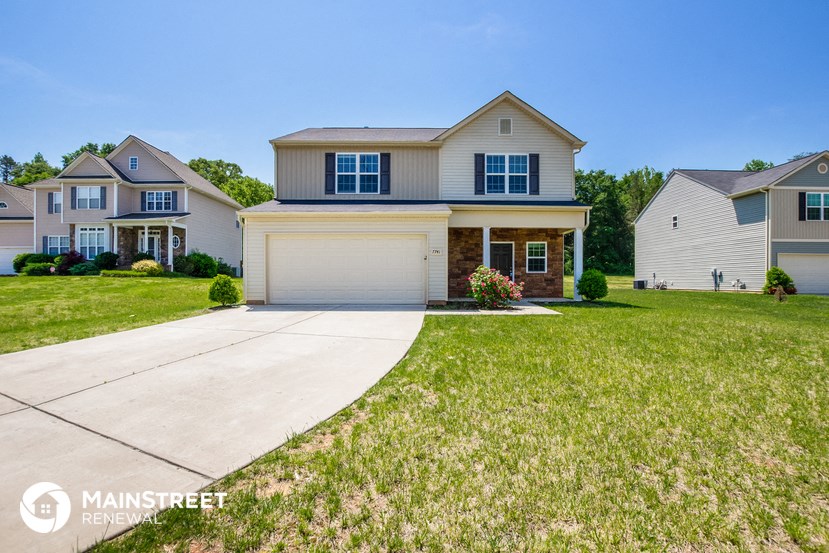 a suburban home with a driveway and a lawn