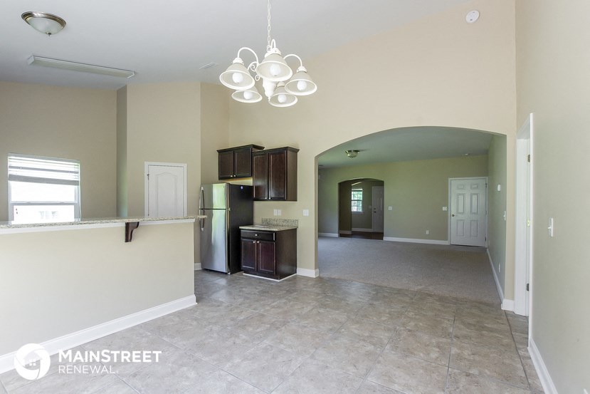 an open kitchen and living room with a white tile floor