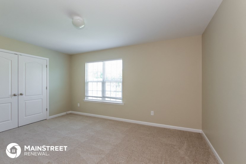 an empty room with a window and a white door