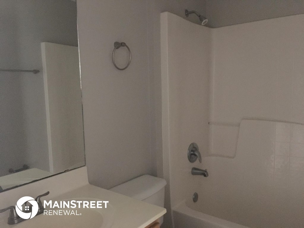 a white bathroom with a tub and a sink and a toilet
