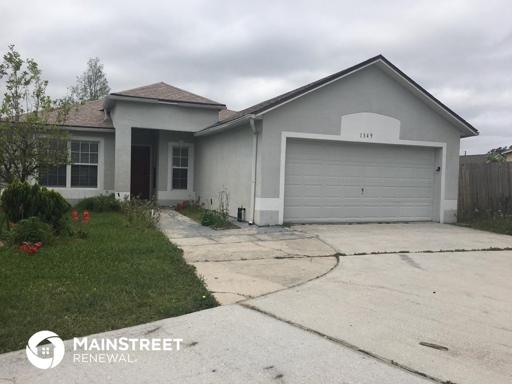 the front of a house with a driveway and a garage door