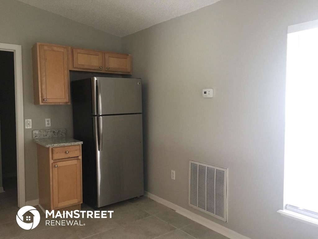 a kitchen with a stainless steel refrigerator and wooden cabinets