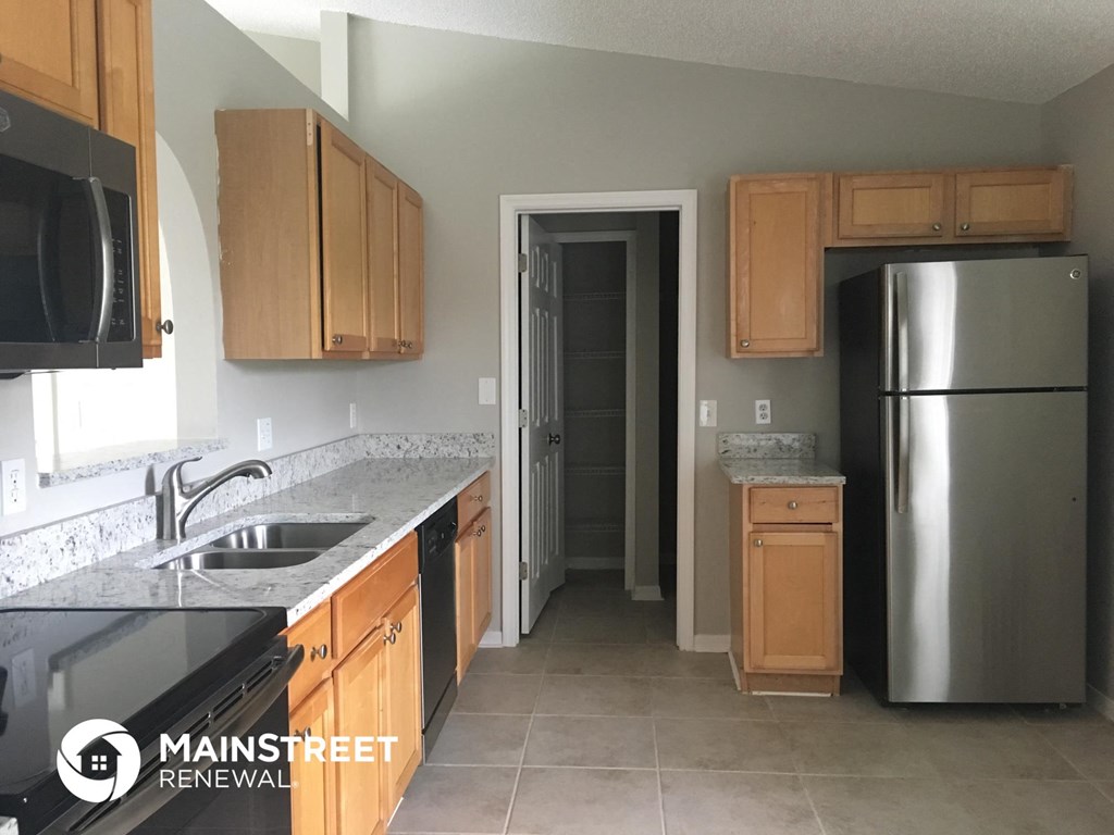 a kitchen with wooden cabinets and a sink and a refrigerator