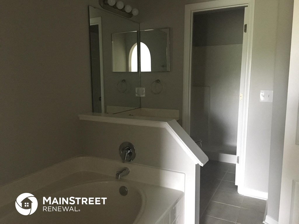 a bathroom with a tub and a mirror in it