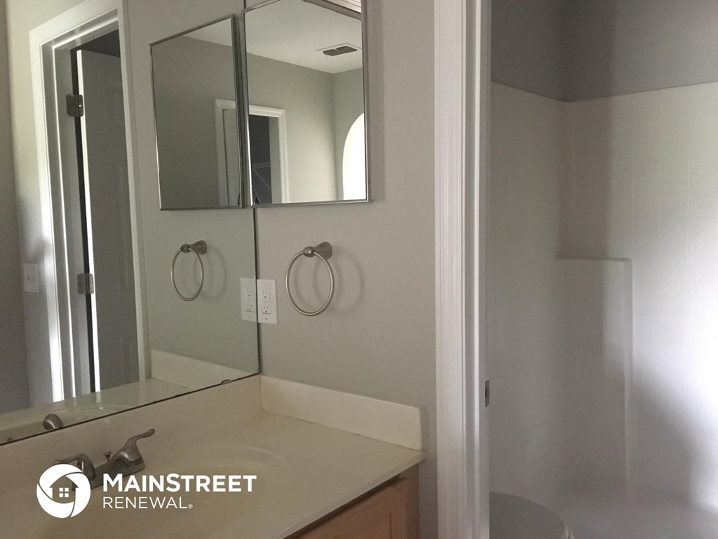 a white bathroom with a sink and a mirror