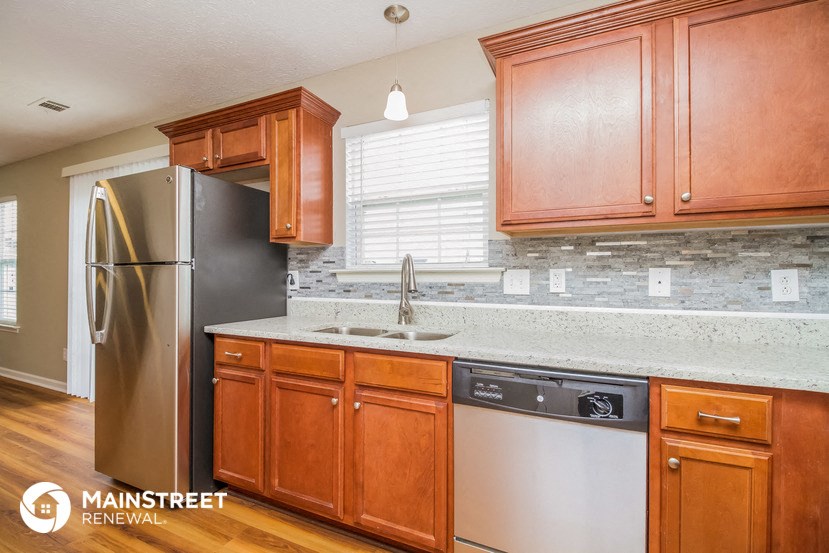 a kitchen with wooden cabinets and a stainless steel refrigerator