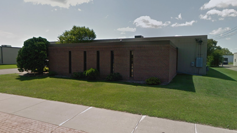 an old brick building with a lawn in front of it