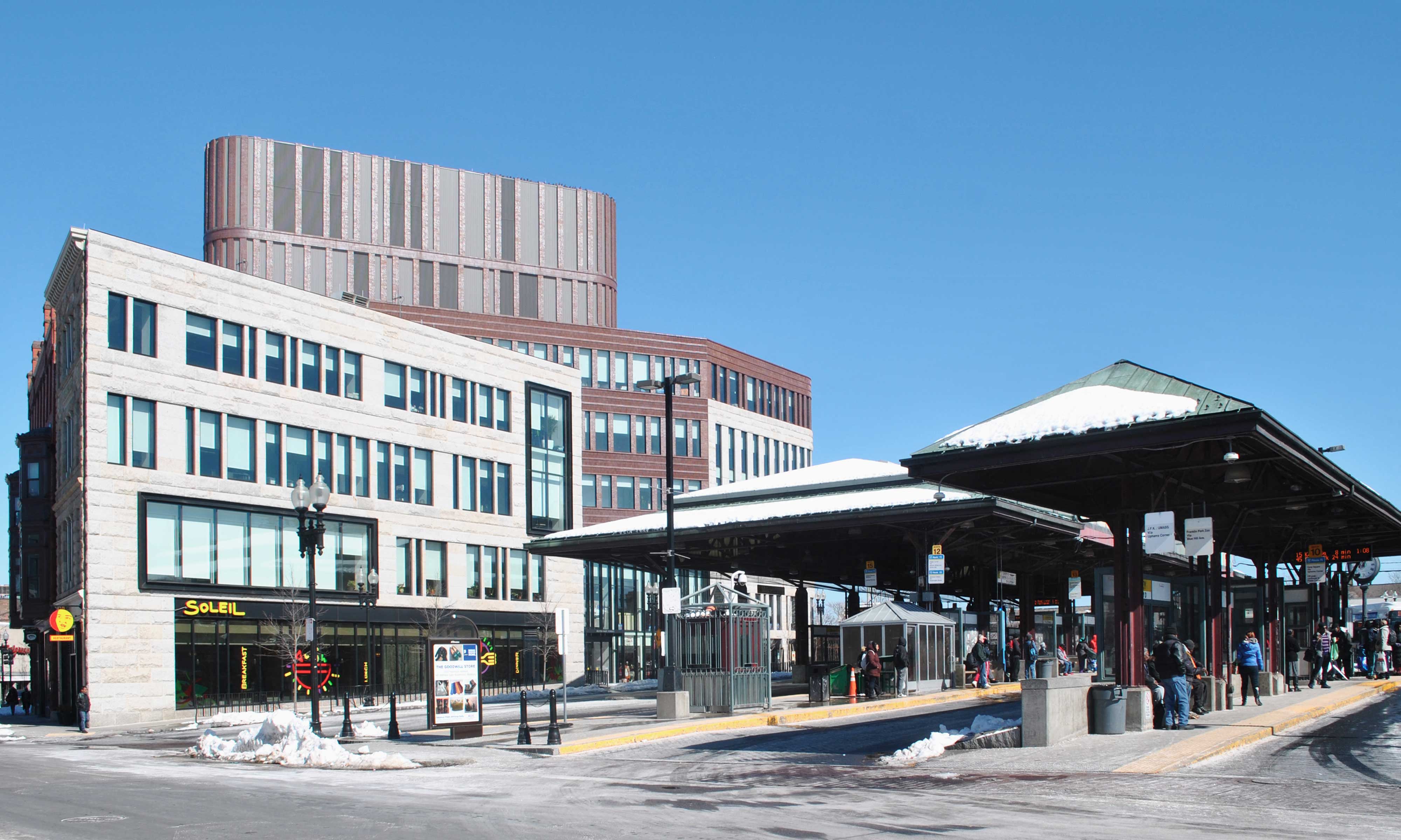 Covered outdoor MBTA station surrounded by local shops and restaurants.