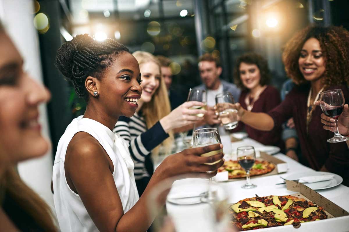 Diverse group of friends dining out together at a nice pizza restaurant