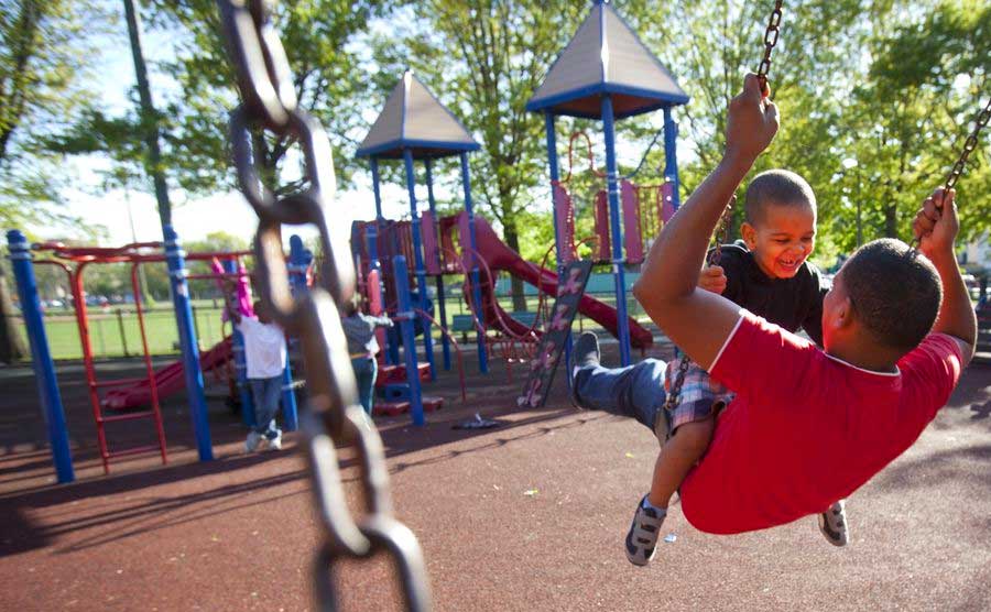 kids playing on swings at Ramsay Park in Roxbury