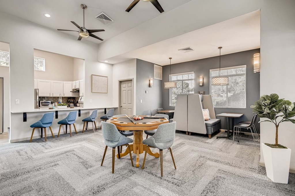 a living room with a table and chairs and a kitchen