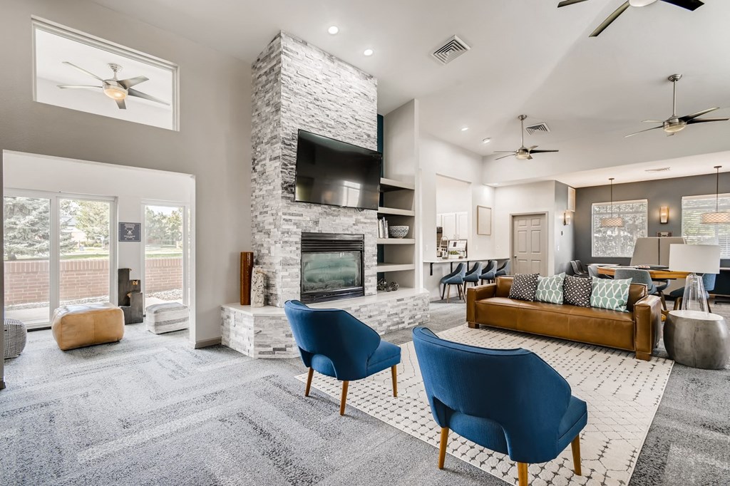 a living room with blue chairs and a fireplace