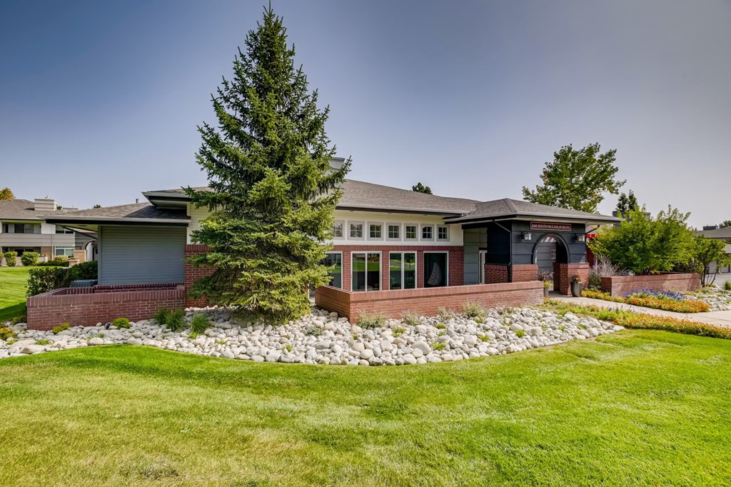 a house with a yard and a tree in front of it