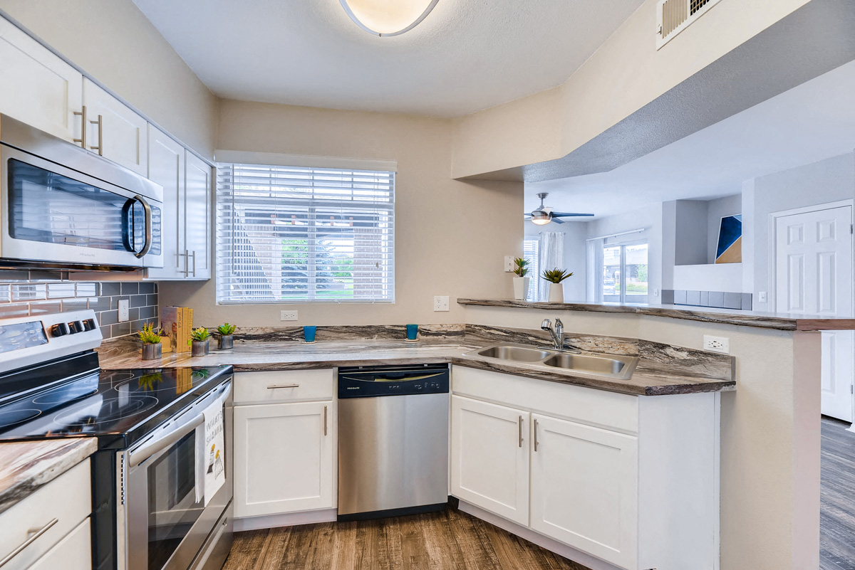 a kitchen with white cabinets and stainless steel appliances