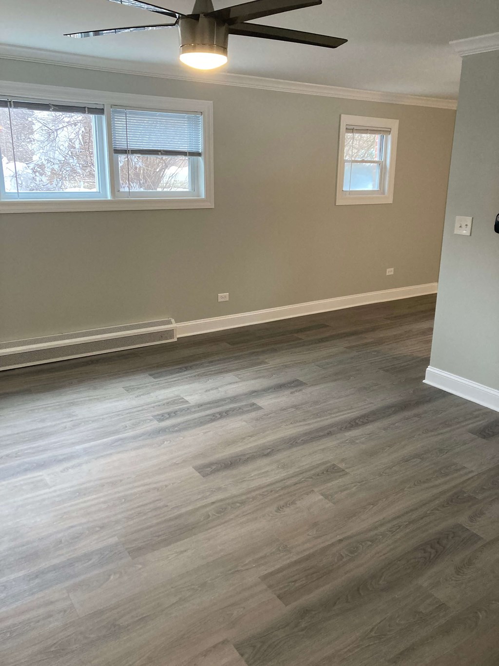 a living room with wood floors and a ceiling fan