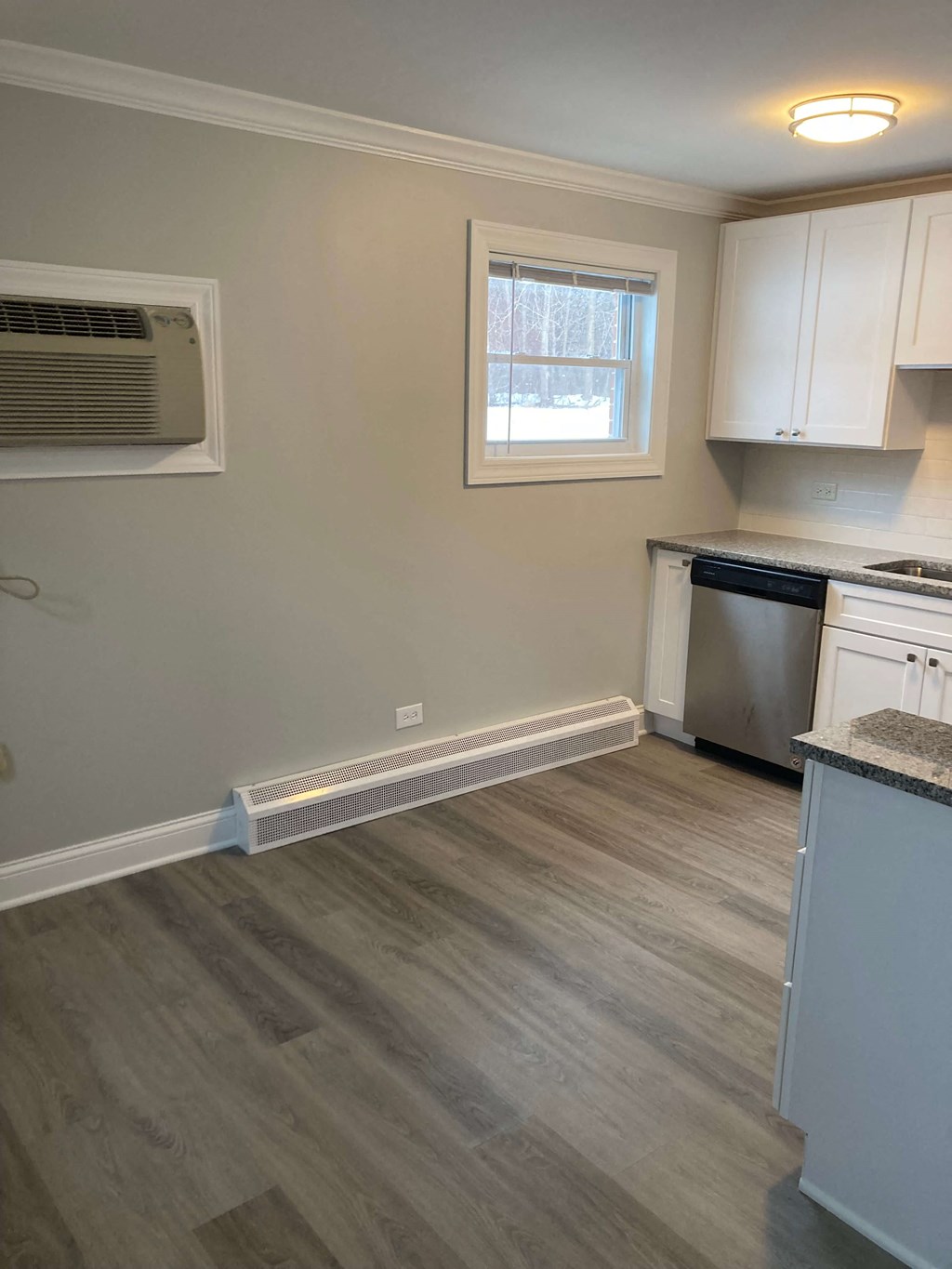 a kitchen with white cabinets and a stove and a window