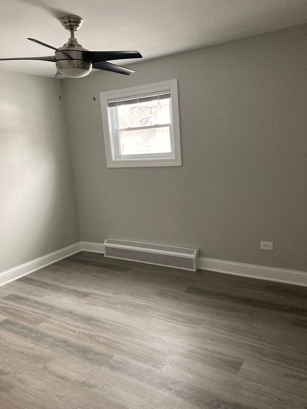 an empty room with a ceiling fan and a window