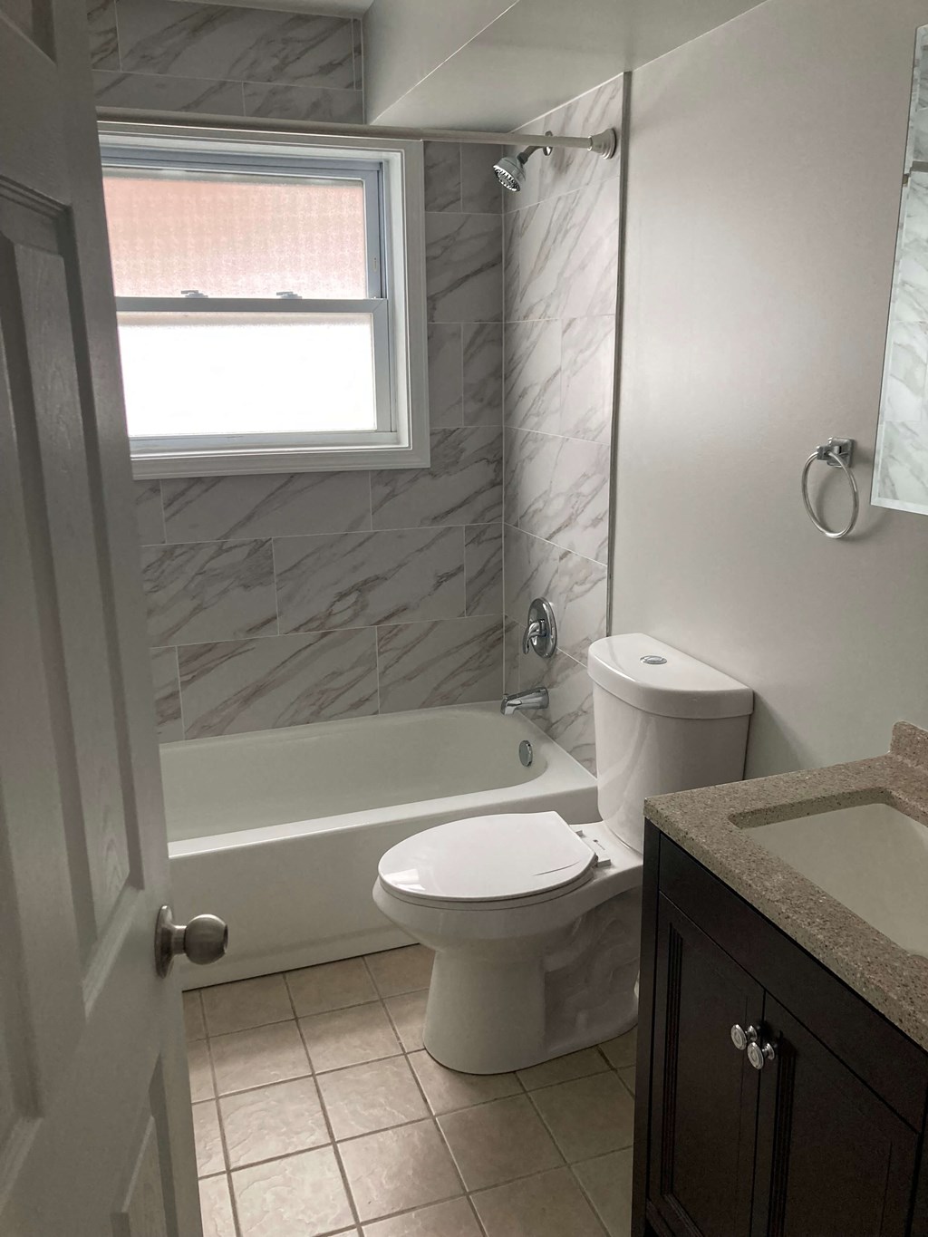 a bathroom with a toilet and a tub and a window