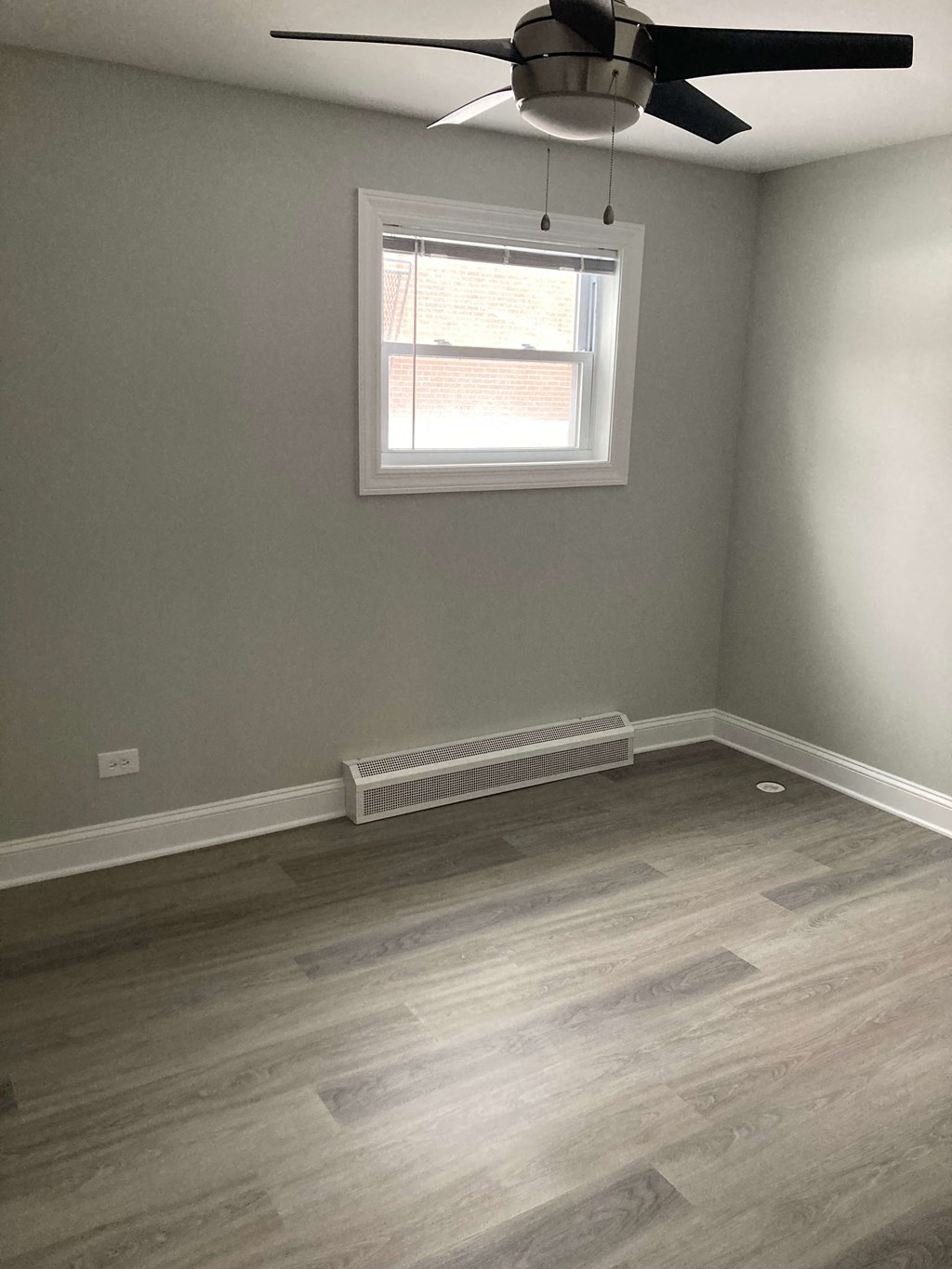 an empty room with wooden floors and a window