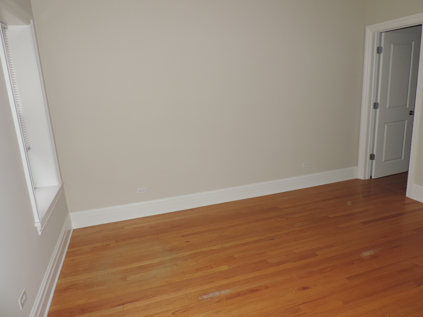 an empty room with wooden floors and a door