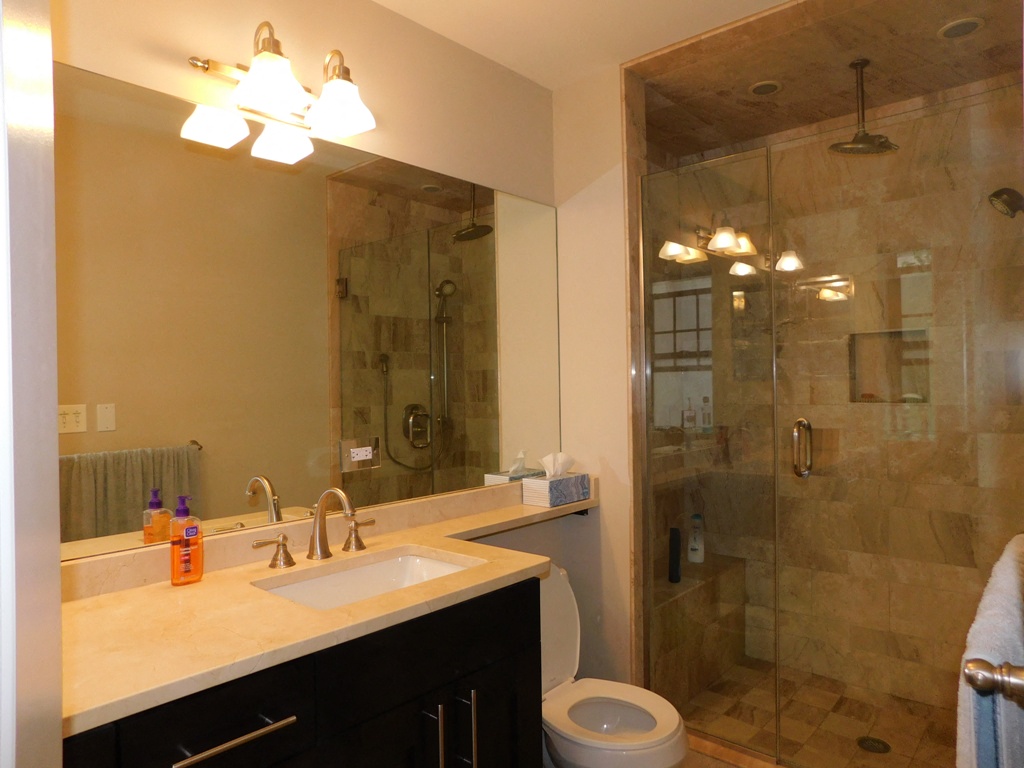 a bathroom with a shower sink and toilet and a mirror