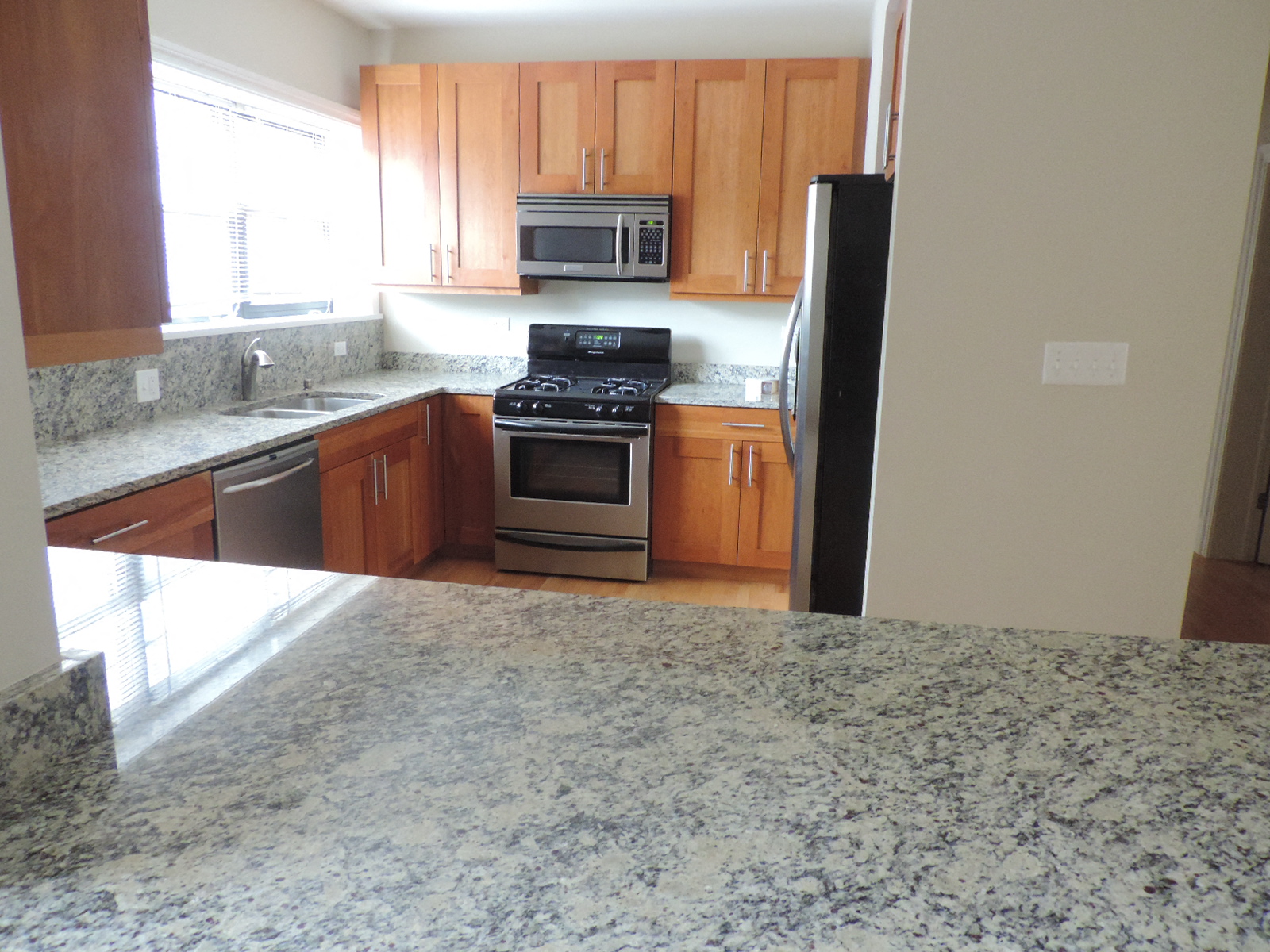 a kitchen with granite counter tops and wooden cabinets